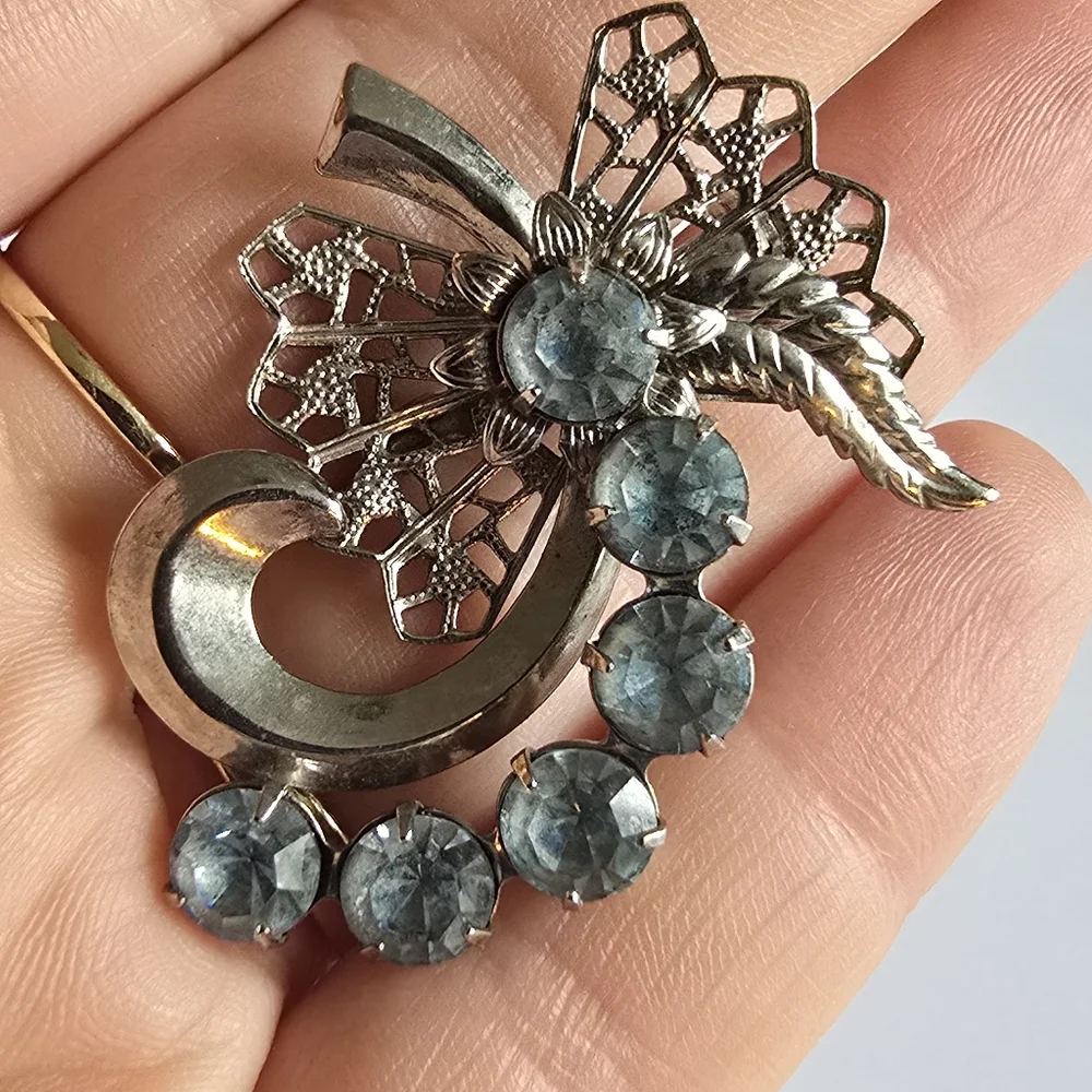 Vintage brooch pin pale blue rhinestones swirl filigree